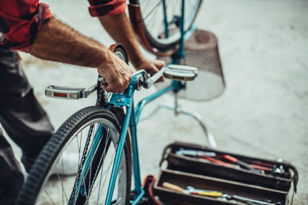 One mature man, repairing his bicycle outdoors alone, part of.